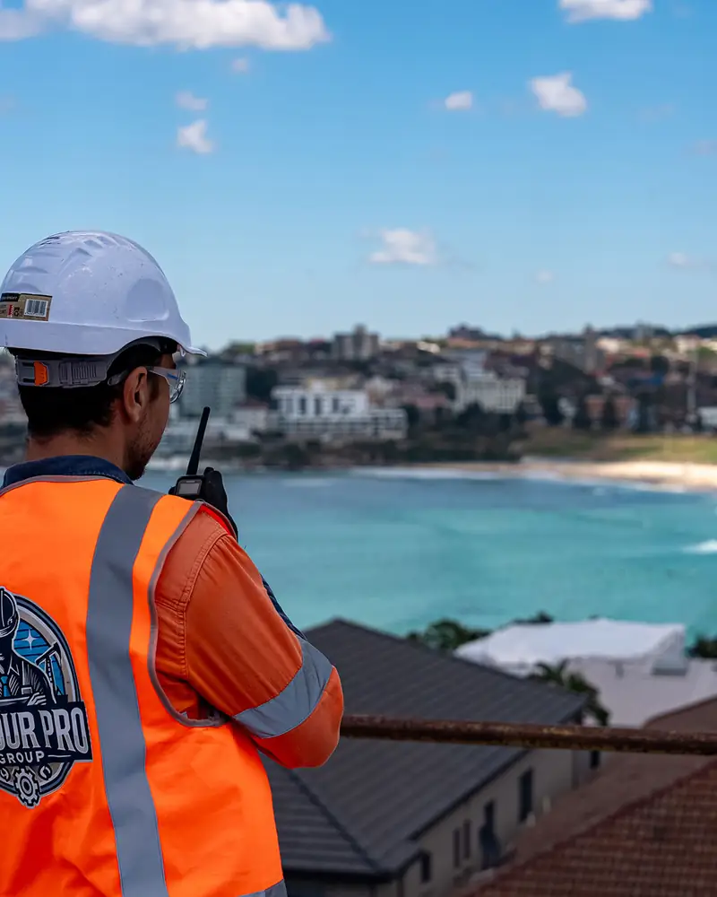 Labour Pro Group worker in branded orange hi-vis overlooking Bondi